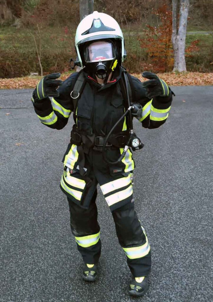 Feuerwehrfrau in voller Uniform mit schwerem Atemschutz
